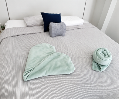 Freshly made bed with folded towels in a tidy bedroom